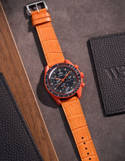 Flat lay of orange embossed alligator leather strap for Omega x Swatch MoonSwatch mission on Earth Lava