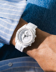 White Vertech rubber strap fitted to an OMEGA x Swatch MoonSwatch Mission to the Moonphase watch, worn on the wrist in a lifestyle shot with clothing visible